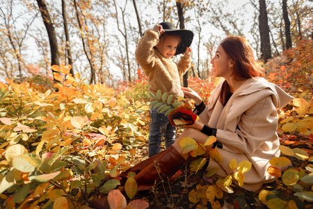 mother and little daughter girl having fun in autumnの写真素材