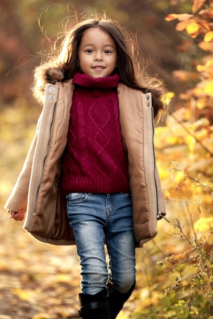 little cut girl playing in autumn park