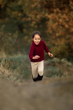 little cut girl playing in autumn parkの写真素材