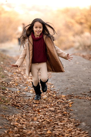 little cut girl playing in autumn parkの写真素材