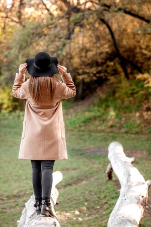 beautiful young woman posing in park in the autumnの写真素材