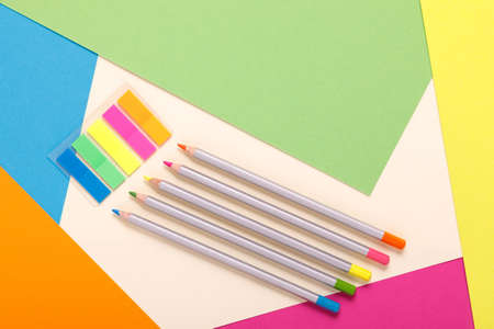 multicolored pencils on multicolored paper, top view