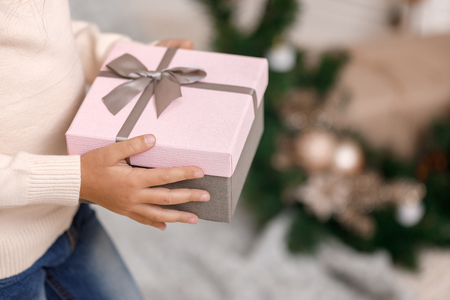 Child hands holding beautiful pink gift boxの写真素材
