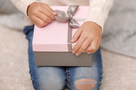 Child hands holding beautiful pink gift boxの写真素材