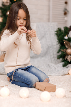 cute child girl packing Christmas gifts at homeの写真素材