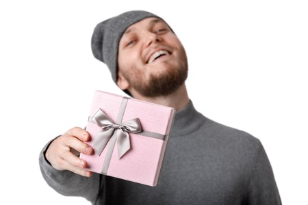 man in gray hat holding gift box on white backgroundの写真素材