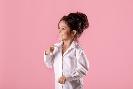Cute smiling little girl in white shirt with hairstyleの写真素材