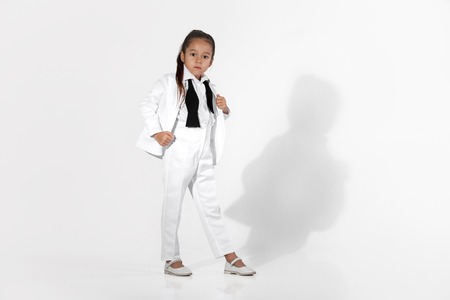 fashion little girl model in a white suit and bow tieの写真素材