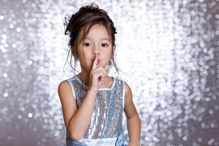 cute smiling little child girl in silver and blue dress