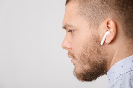 calm bearded young businessman uses wireless headphones.
