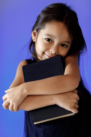 cute little girl is reading a book.の写真素材