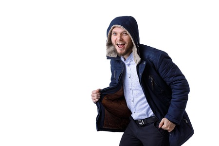 Smiling young guy in winter warm coat. Fashionable man wearing blue winter jacketの写真素材