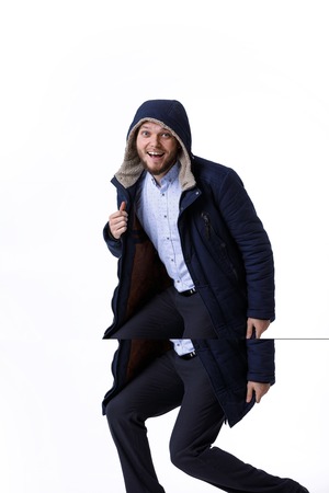 Smiling young guy in winter warm coat. Fashionable man wearing blue winter jacketの写真素材