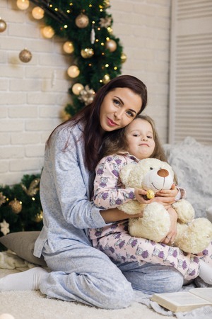 happy mother with her little child daughter playing near the Christmas treeの写真素材