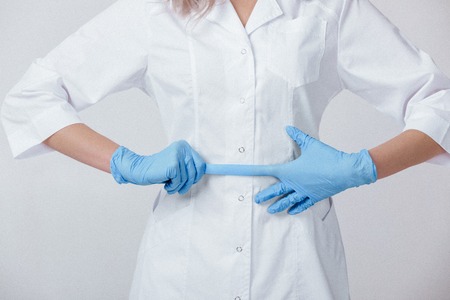 Woman doctor hands wears medical latex blue gloves, close-upの写真素材