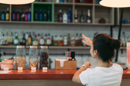 young attractive woman makes an order in a cafeの写真素材