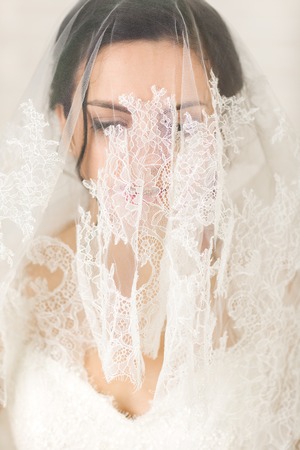 Beautiful bride portrait with veil over her face