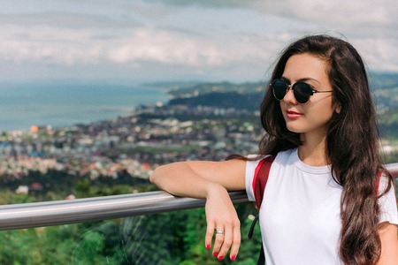 beautiful woman in sunglasses looking at panoramic view of the city of Batumi in sunny day