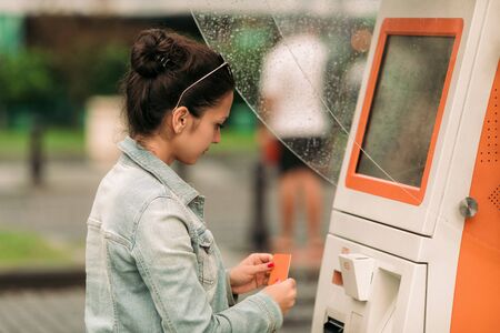 Tourist woman buys tickets for transport in Georgia. modern street machine for purchase of tickets...