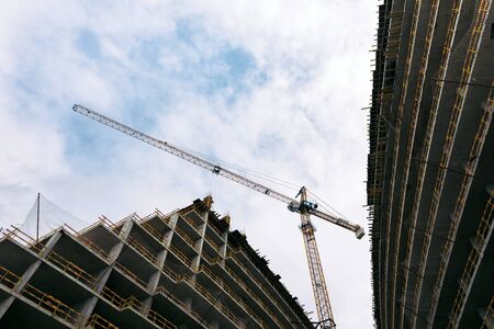 construction yellow crane and building construction site against blue sky