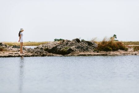 young woman walks along the seashore at the day