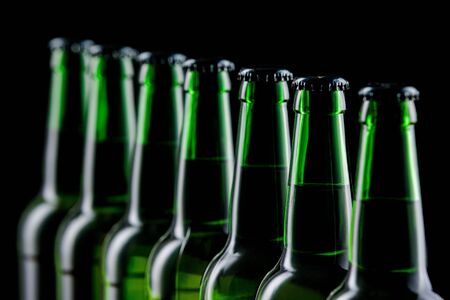 Row of glass bottles of beer on dark backgroundの写真素材