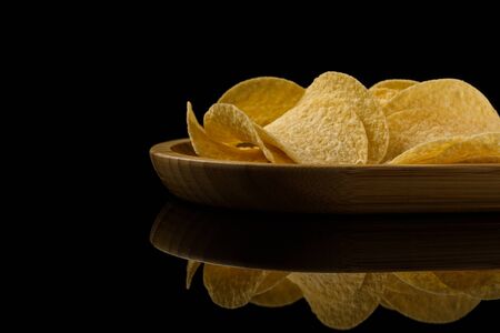 Salty delicious potato chips on black backgroundの写真素材