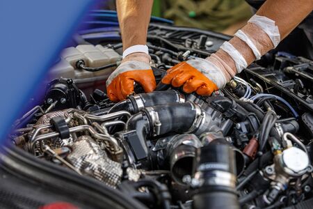 Automobile mechanic repairing a car engine. man fixing the engine car. service and maintenance.