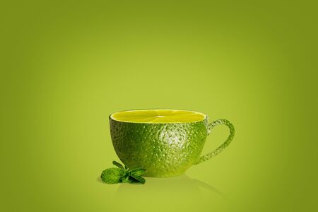 Cup of tea with mint and lime on green backgroundの写真素材