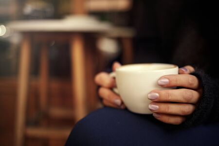 Female hand hold hot coffee cup in cafeの写真素材