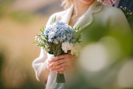 beautiful wedding bouquet of flowers in bride's handsの写真素材