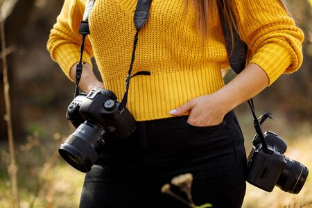 woman photographer stand ready to work. photographer with two digital cameraの写真素材