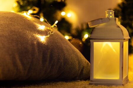 christmas lantern. Christmas interior decorated with lights garland. New Year gifts