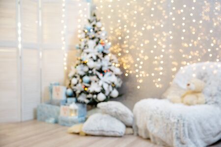 blur background of Christmas tree decorated with lights garland. room with christmas interiorの写真素材