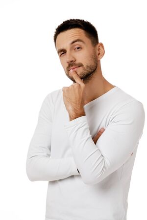 portrait of doubtful bearded man in casual white shirt asking questions isolated on white background.の写真素材
