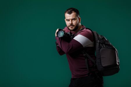 bearded man photographer takes images with professional digital photo camera. copy spaceの写真素材