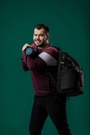 bearded man photographer takes images with professional digital photo cameraの写真素材