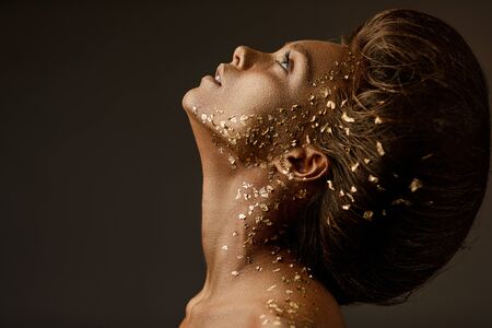 Fashion art portrait of model girl with holiday golden shiny professional makeup. beaty woman with...