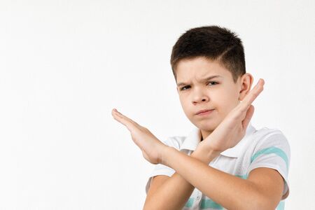 Cute little child boy in t-shirt making stop gesture on white background.の写真素材