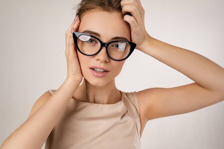 Portrait of woman model in dress wearing glasses against gray backgroundの写真素材