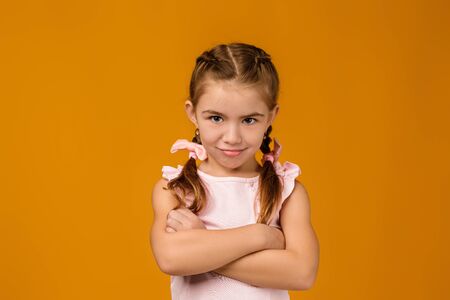 offended sad little child girl in dress on yellow background. Human emotions and facial expressionの写真素材
