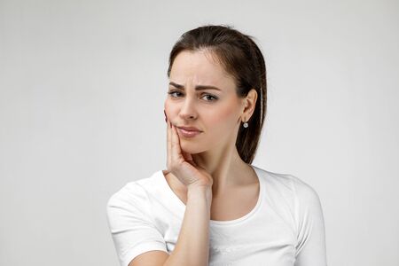 young sad woman suffering from tooth pain, caries. girl having toothache. Dental health and care conceptの写真素材