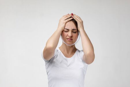 young sad woman suffering from tooth pain, caries. girl with bandage on her face having toothache. Dental health and care conceptの写真素材