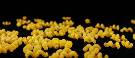 Italian raw pasta on black background. macaroni cellentaniの写真素材