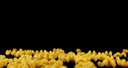 Italian raw pasta on black background. macaroni cellentani. copy spaceの写真素材