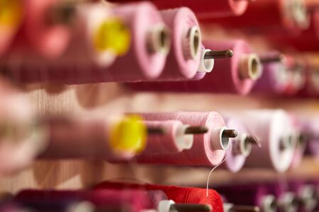 Colorful cotton thread rolls for sewing machine in store. thread spools for garment industry