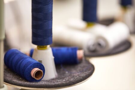 cotton thread rolls for sewing machine. blue and white thread spools for garment industry