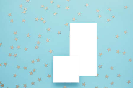Empty card and gold confetti on blue background. Mockup template. top viewの写真素材