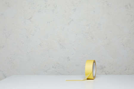 Roll of yellow paper masking tape on wooden table. copy spaceの写真素材