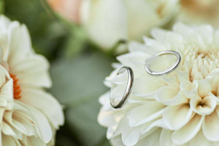 two wedding rings and beautiful flower bouquet, close-upの写真素材